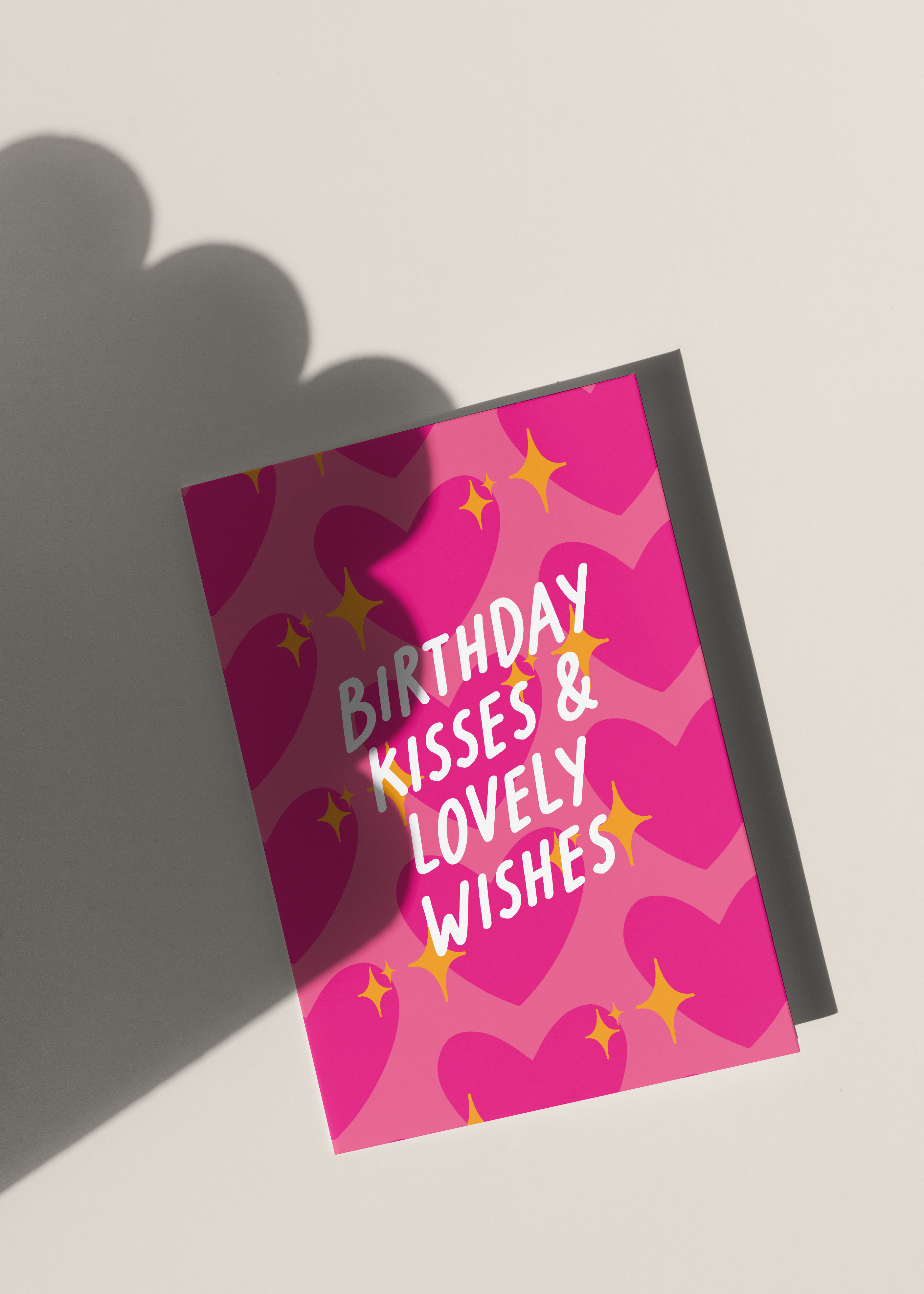 Pink birthday card with text and pink sparkling heart emoji heart patterns on a light background